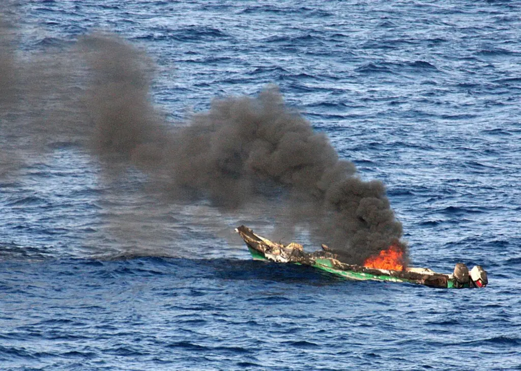 Suspected pirate skiff burns after attack. Photo: US Navy/JRZalasky