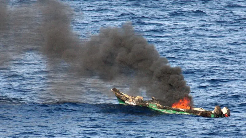 Suspected pirate skiff burns after attack. Photo: US Navy/JRZalasky