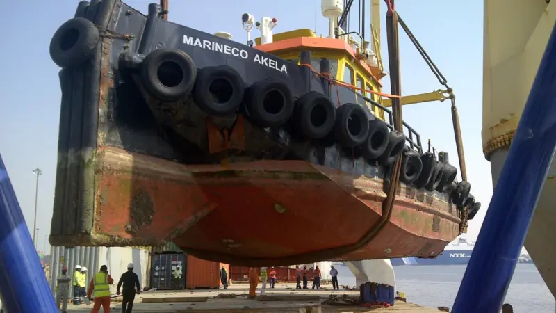 The tug is lifted onto the deck of the ‘Atlant Frauke’