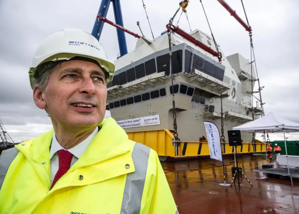 The QE Class carrier’s forward island lift was witnessed by UK Defence Secretary Philip Hammond