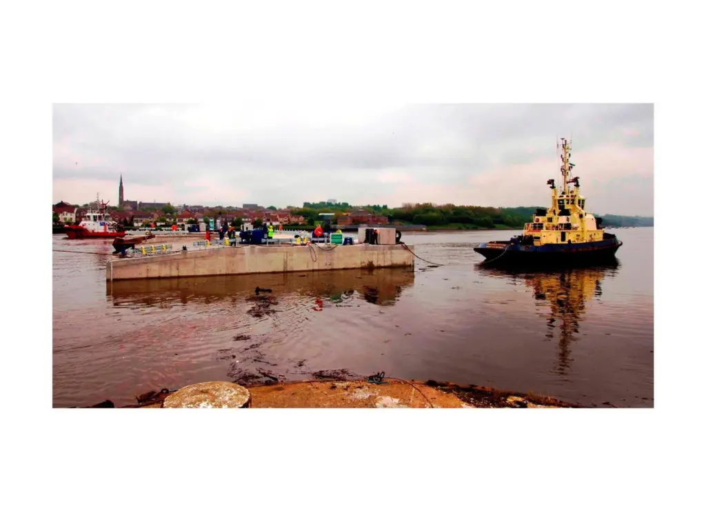 A tug is seen moving the pontoon away from its build site at Neptune Energy Park