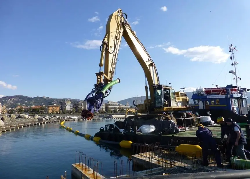 The dredging bucket was installed on a CAT excavator that worked from a floating pontoon
