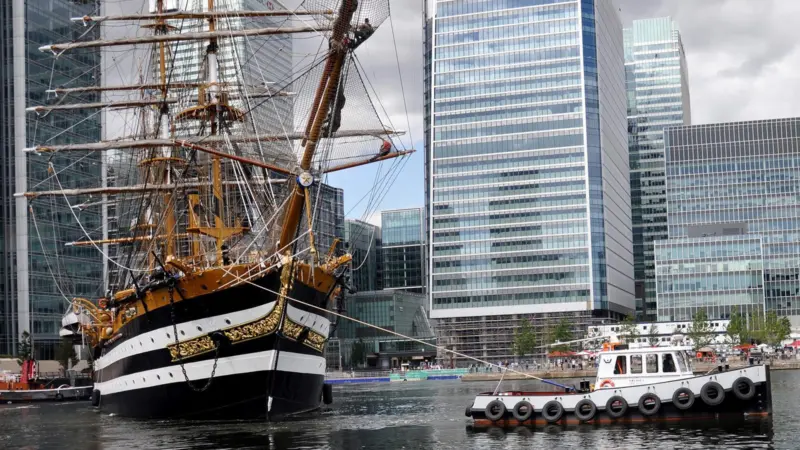 The tug/workboat Devious is seen swinging the Italian training ship Amerigo Vespucci in London Docklands