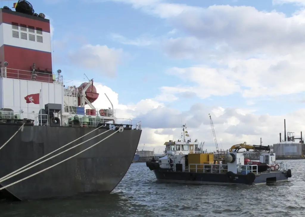 A Hydrex workboat with equipment is seen next to a tanker in Antwerp
