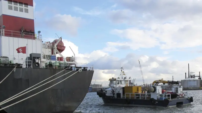 A Hydrex workboat with equipment is seen next to a tanker in Antwerp