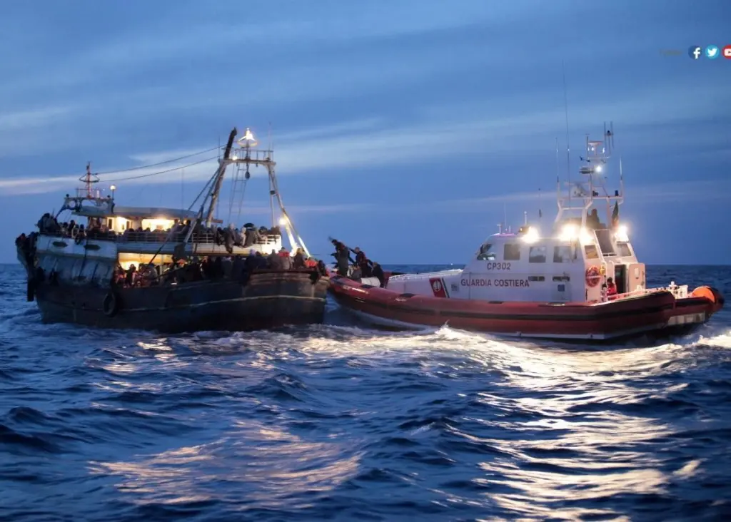 An Italian coastguard vessel approaches a people smuggling vessel in the Mediterranean (Photo International Organisation for Migration)