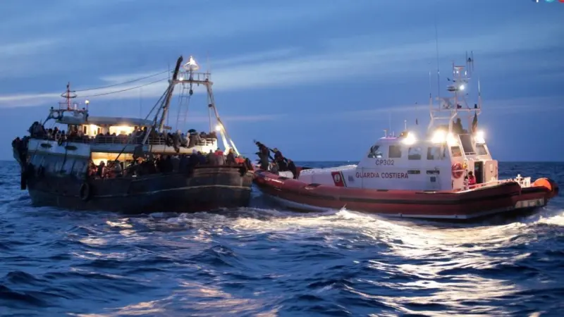 An Italian coastguard vessel approaches a people smuggling vessel in the Mediterranean (Photo International Organisation for Migration)