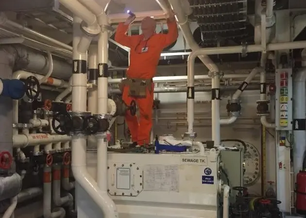 A surveyor looking at pipe system flanges
