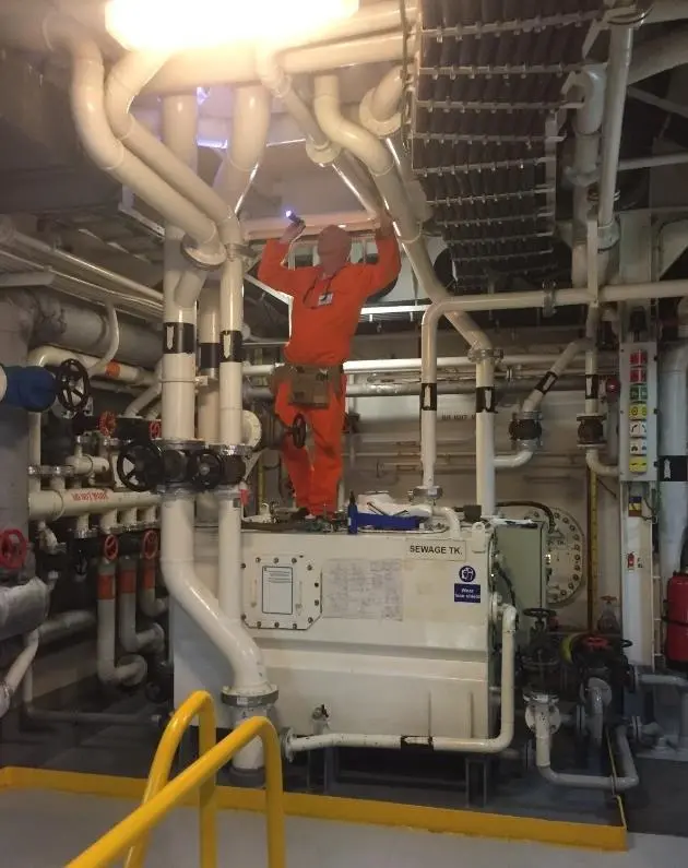 A surveyor looking at pipe system flanges