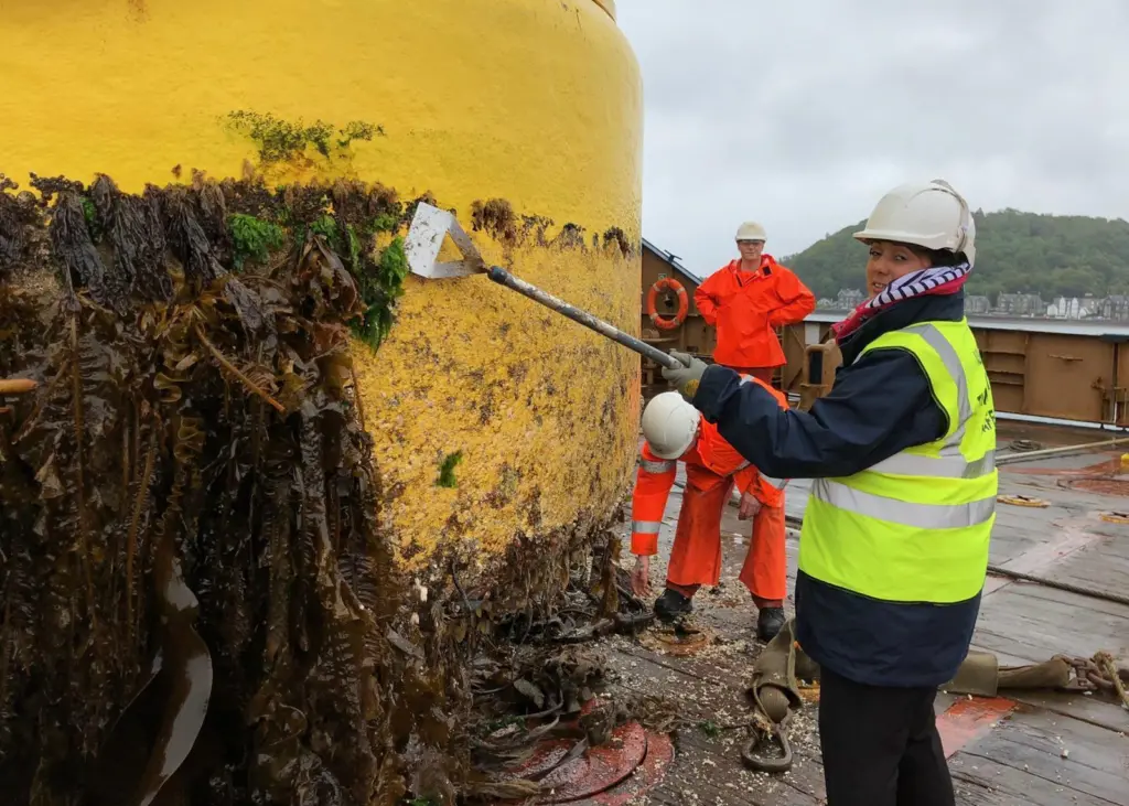 During the visit the Minister was given a tour of the buoy yard and had a go at some cleaning Photo: NLB
