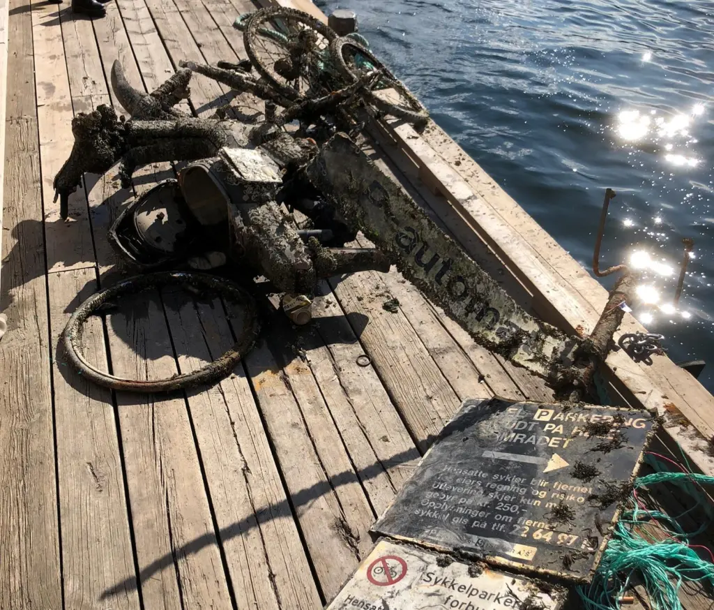 Harbour signs, a tangle of bikes and a moped are pulled from beneath Oslo's pristine surface. Photo: Oslo Havn