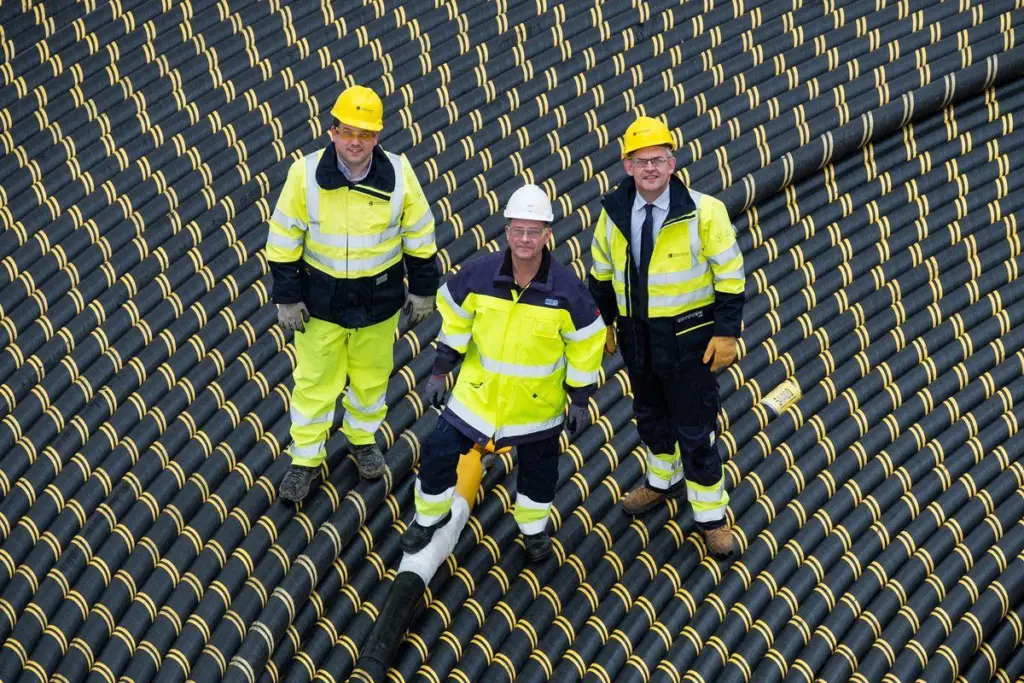 Craig Taylor (SSEN), Arne Abrahmsson (NKT) and Brian Mitchell (SSEN) stand on top of the cable reel