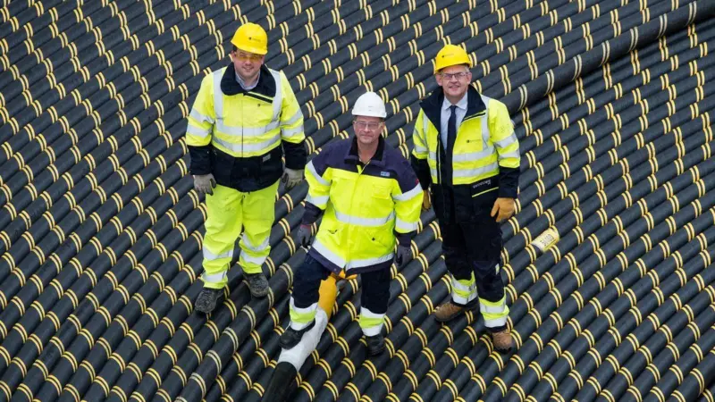 Craig Taylor (SSEN), Arne Abrahmsson (NKT) and Brian Mitchell (SSEN) stand on top of the cable reel