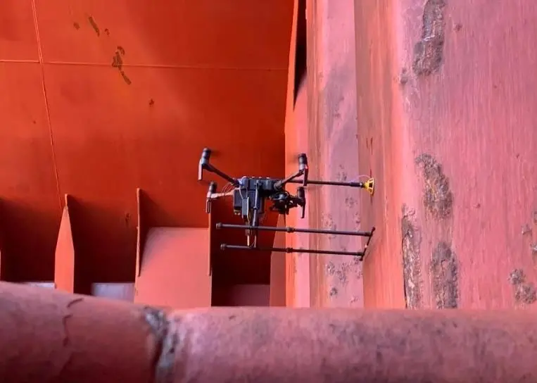 Airborne drone conducting ultrasonic thickness measurements inside the hold of a bulk carrier