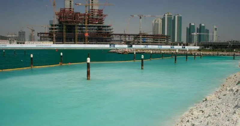 The silt curtain barrier provides a clearly visible line, showing the dramatic difference in turbidity. Photo: Ecocoast
