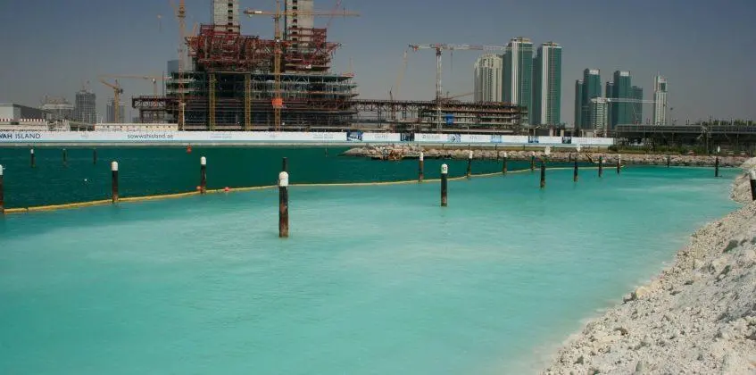 The silt curtain barrier provides a clearly visible line, showing the dramatic difference in turbidity. Photo: Ecocoast