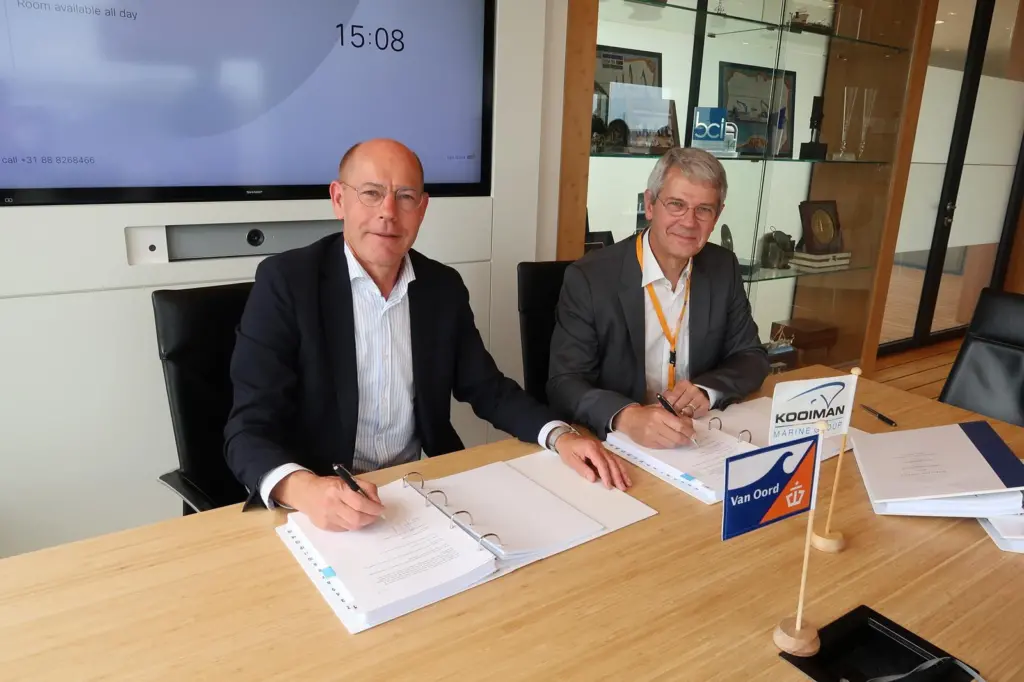 A representative from Van Oord and one from Kooiman Group signing a contract for a dredger order