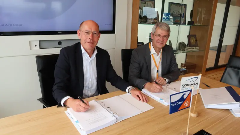 A representative from Van Oord and one from Kooiman Group signing a contract for a dredger order
