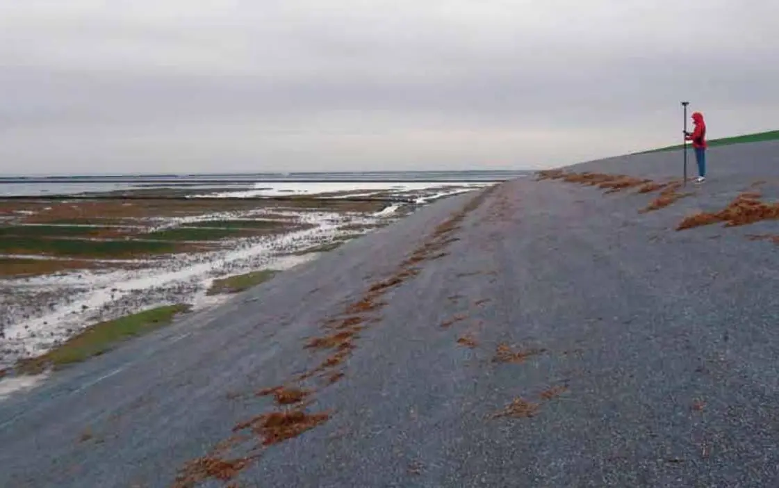 EMB Measuring the position of flood marks on the dyke along the Dutch Wadden Sea