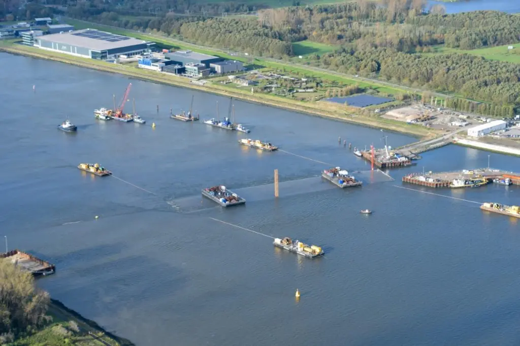 Four moored barges manoeuvre the tunnel section into position (Rijkwaterstaat)