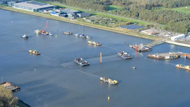 Four moored barges manoeuvre the tunnel section into position (Rijkwaterstaat)