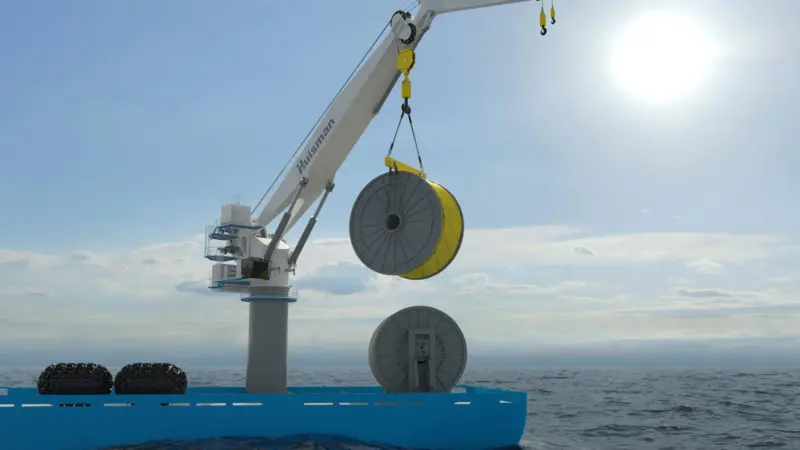 The images shows a Huisman Knuckle Boom Crane performing lifting operations
