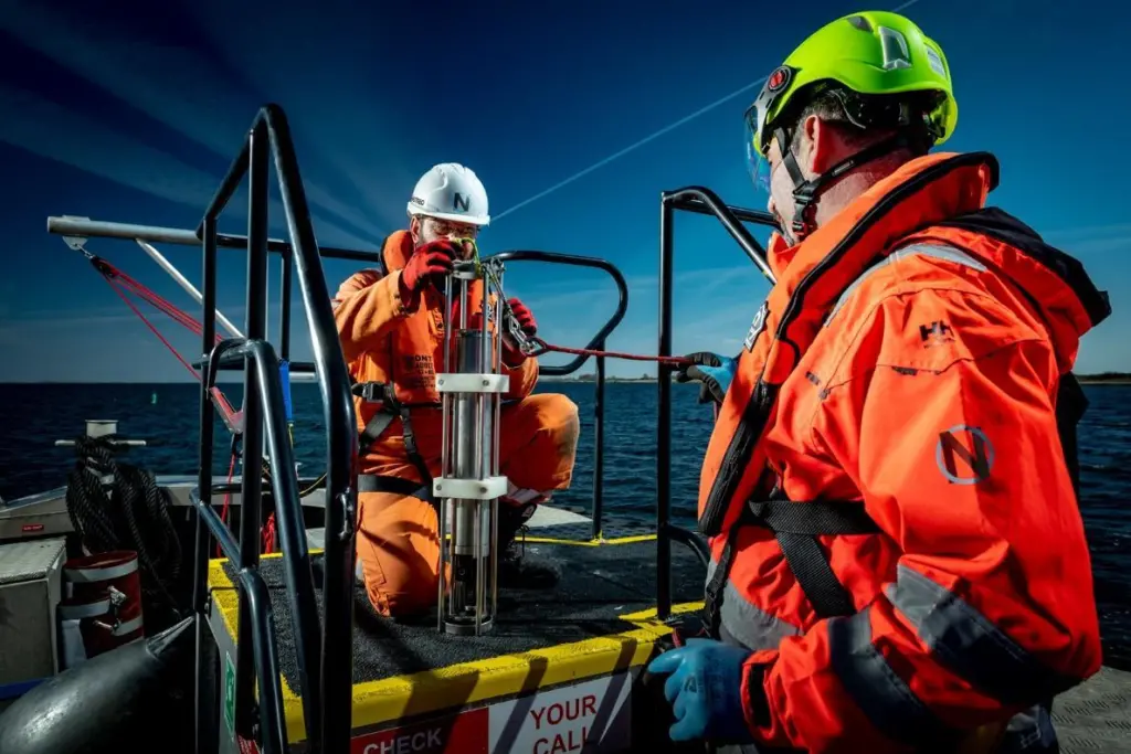 The image shows NextGeo workers onboard a vessel