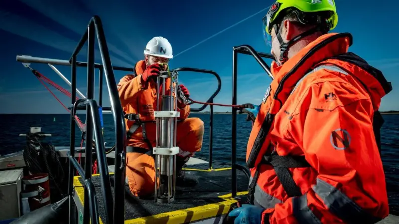 The image shows NextGeo workers onboard a vessel