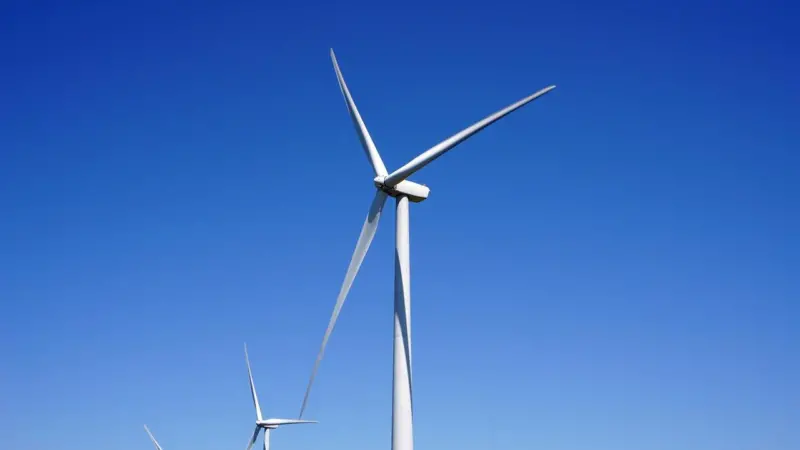 The image shows an up close picture of some offshore wind turbines