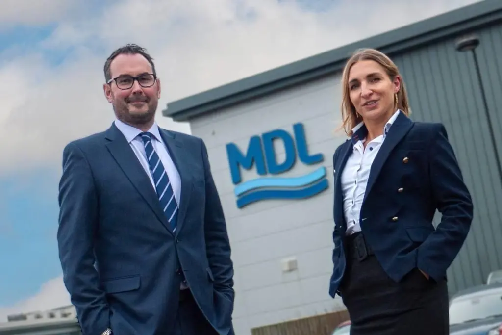 The image shows Aleksandra Jurczak and Ramsay Keay standing outside MDL HQ