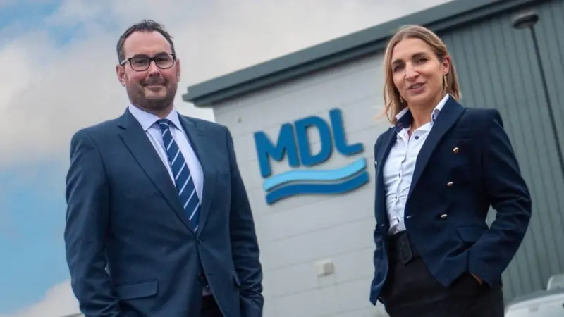 The image shows Aleksandra Jurczak and Ramsay Keay standing outside MDL HQ