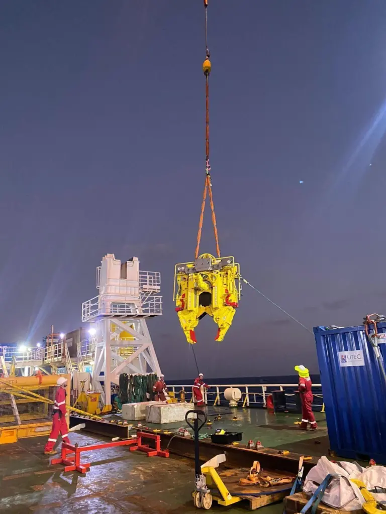 Decom Engineering's C1-24 Chopsaw in action. The saw is suspended above a ship's deck with workers