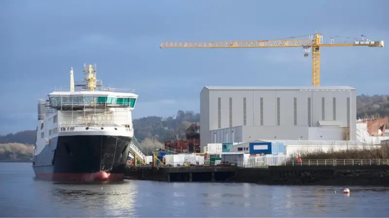 Ship next to warehouse and crane