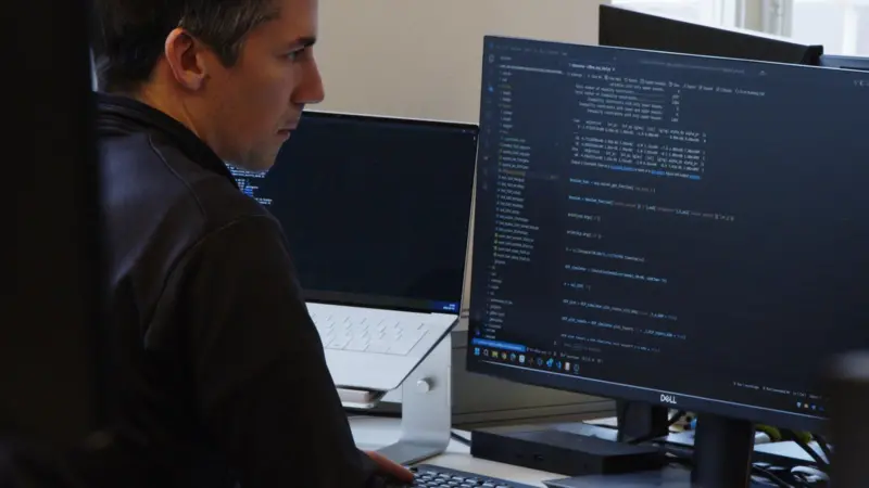 The image shows a male user accessing AI modelled data on a computer screen