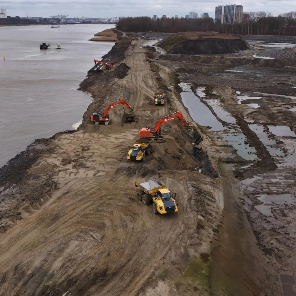 Construction vehicles breaching a dyke at the Scheldt river in Antwerp