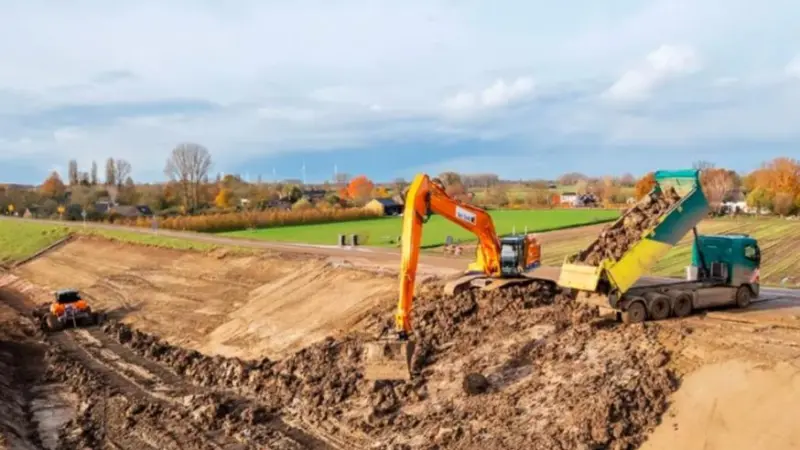 The image shows electric equipment being used during the dyke reinforcement project commissioned by Rivierenland Water Board.