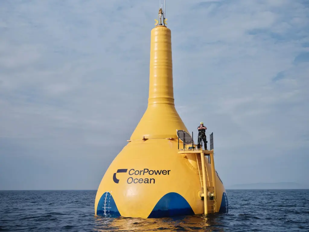 A giant CorPower Ocean yellow buoy with a man standing on top