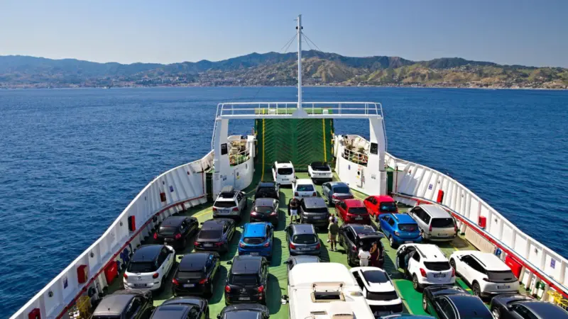 Cars on board a RoRo ferry at sea with land in the background