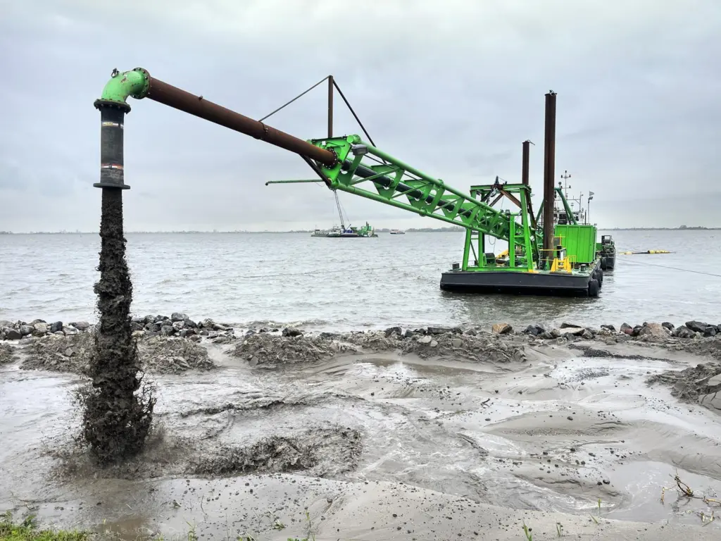 DEME dredger at work reinforcing the dyke at Marken