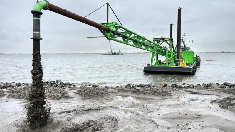 DEME dredger at work reinforcing the dyke at Marken