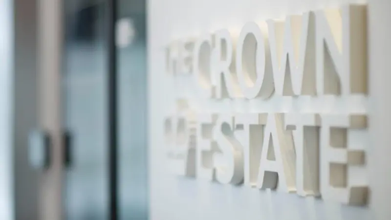The image shows a wall emblazoned with The Crown Estate