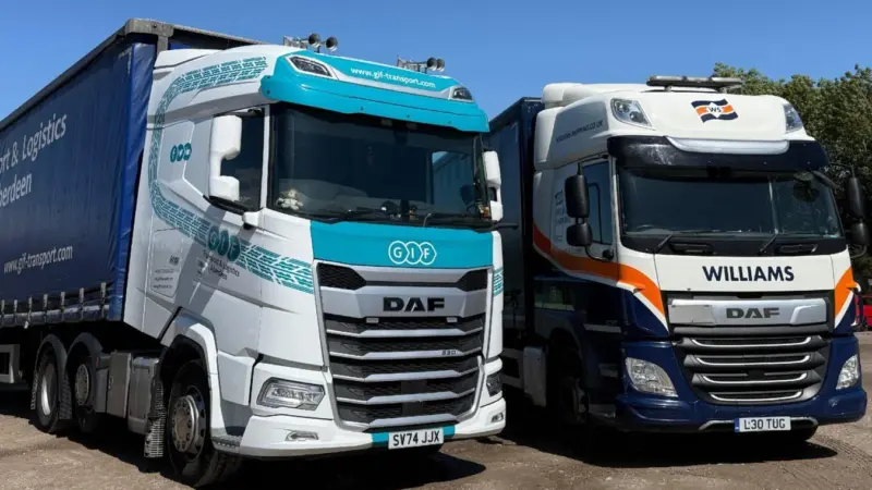 The image shows a Williams Shipping and GIF Transport truck side by side