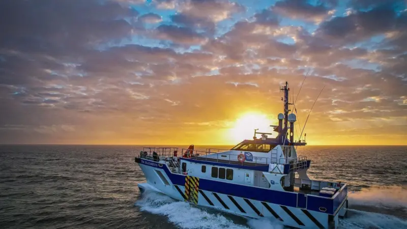 The image shows a Tidal Transit CTV on the water at sunset