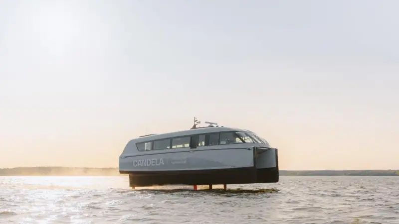 The image shows the Candela P-12 electric ferry on the water