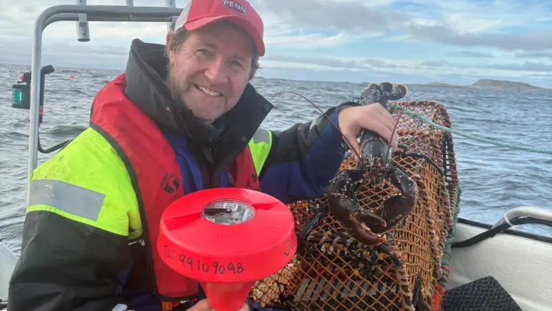 The image shows John Olav Florø-Larsen on board his vessel with the SmartOcean wave indicator