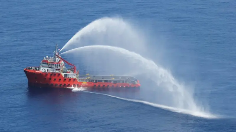 A service vessel at sea spraying water