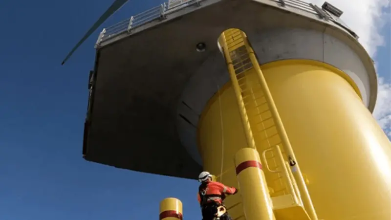 A worker scaling the side of a wind turbine from Seatrium